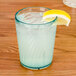 A jade GET Tahiti plastic tumbler filled with a blue drink, ice, and a lemon wedge.