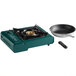 A green Choice portable gas stove with brass burner and frying pan.