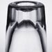 A close up of a Libbey fluted shot glass with a clear glass vase with a black rim.