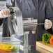 A person using a Garde Rotoslice machine to slice vegetables on a counter.