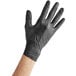 A hand wearing a black Noble NexGen disposable glove.