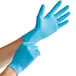 A person wearing blue Noble NexGen disposable gloves.