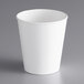 A Dart ThermoGuard white paper hot cup with a white rim on a gray surface.