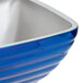A close up of a Vollrath cobalt blue stainless steel bowl with a silver rim.