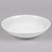 A white Reserve by Libbey porcelain coupe bowl on a gray surface.