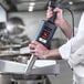 A chef using a Sammic XM-52 heavy-duty hand held immersion blender in a professional kitchen.