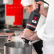A chef using a Sammic medium-duty variable speed immersion blender with a whisk attachment.