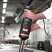 A chef using a Sammic XM-51 heavy-duty immersion blender in a professional kitchen.