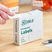 A box of Noble 1" x 2" permanent blank labels containing 500 labels per roll.