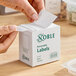 A box of Noble 2" x 2" removable blank labels containing 500 labels per roll.
