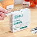 A box of Noble 1" x 2" permanent food rotation labels containing 500 labels per roll.