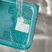 Water running over a Noble Products Friday dissolvable food label on a plastic container.