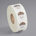 A roll of white labels with brown and white writing on them.