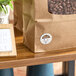 A brown paper bag with a round Thursday day-of-the-week clock label attached to it.
