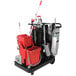A black and red Unger RestroomRx cleaning cart with buckets and mops.