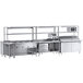 A Chef's Counter stainless steel work table with a sandwich prep table, steam table, and dish cabinets.
