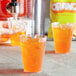A close-up of a plastic cup with orange DominAde.