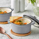 Two Valor slate grey enameled mini cast iron pots with soup and bread on a table.
