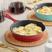 Two Valor cranberry apple enameled cast iron skillets with potato casserole on a table.