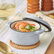 A Valor Glacier enameled mini cast iron pot with shrimp and vegetables in it.