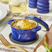 A Valor Galaxy Blue enameled cast iron pot with food in it and the lid open.