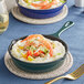 A Valor green enameled cast iron skillet with shrimp and vegetables.