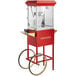 A red and gold Carnival King Kettle Corn popcorn machine on a stand with wheels.