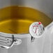 An AvaTemp candy thermometer on a pot of liquid.
