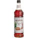 A close up of a Monin Premium Cinnamon Bun Flavoring Syrup bottle.