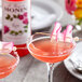 Two pink drinks made with Monin Premium Rose Flavoring Syrup with flowers on top.