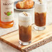 Two glasses of iced coffee with Monin Natural Hazelnut Syrup.
