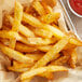 A basket of french fries with Lawry's Garlic Salt and ketchup on a white background.