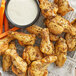 A plate of Lawry's Lemon Pepper chicken wings with carrots and dip.