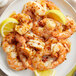 A plate of shrimp with Lawry's Santa Fe-Style Seasoning and lemon wedges.