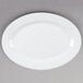 A Tuxton Alaska white china platter with a wide rim on a gray surface.