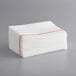 A stack of white paper towels with red lines.
