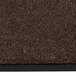 A close up of a dark toast brown Notrax carpet with a black border.