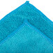 A close up of a Unger SmartColor blue microfiber cleaning cloth with two small holes.