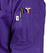 A purple Uncommon Chef short sleeve chef coat with a pocket and pen holder.