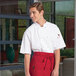 A man wearing an Uncommon Chef white short sleeve chef coat with mesh venting.