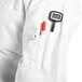 A person wearing a Uncommon Chef Delray Pro Vent white chef coat with a pen in the pocket.