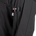 A Uncommon Chef black long sleeve chef coat with a pen holder and mesh back.