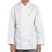 A woman wearing an Uncommon Chef white long sleeve chef coat.
