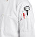 A person wearing a Uncommon Chef white chef coat with a pen in the pocket.