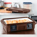 A dark brown Cambro Ultra Pan Carrier with food inside.