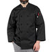 A man wearing a black Uncommon Chef coat with black pants.