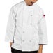 A man wearing a white Uncommon Chef 3/4 sleeve chef coat.