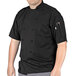 A man wearing a black Uncommon Chef Aruba Pro Vent short sleeve chef coat with mesh back.