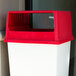 A white and red Rubbermaid Glutton square top lid on a red trash can.