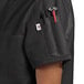 A black Uncommon Chef short sleeve chef coat with red accents on the pocket worn by a person.